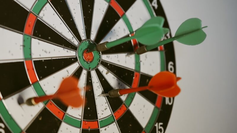 Het vermogen van Gerwen bereikt €10 miljoen in 2026 Success hitting target aim goal achievement concept background - three darts in bull's eye close up. red three darts arrows in the target center business goal concept